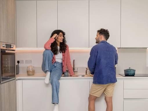 A man and a woman are standing in a kitchen.
