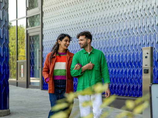 Two people walking together on a sidewalk.