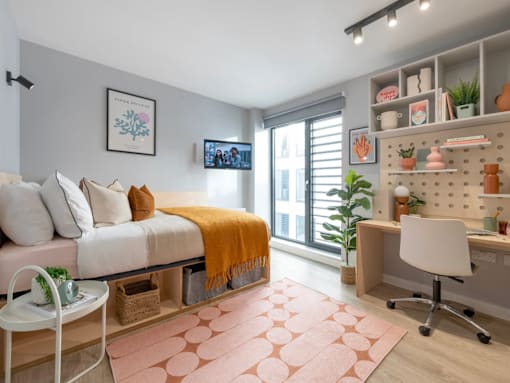 A cozy bedroom with a bed, desk, and chair.