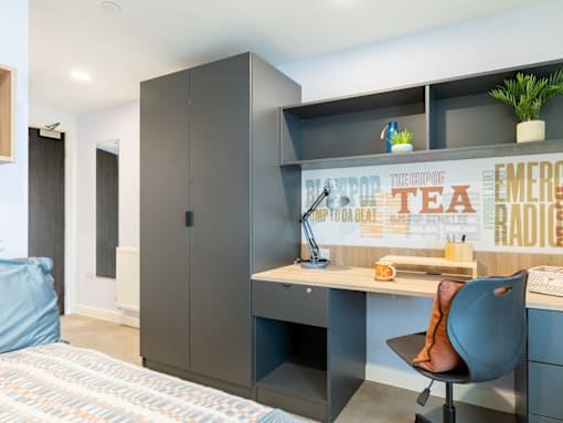 A modern bedroom with a bed, desk, and chair.
