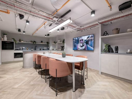 A modern kitchen with a long table and chairs.