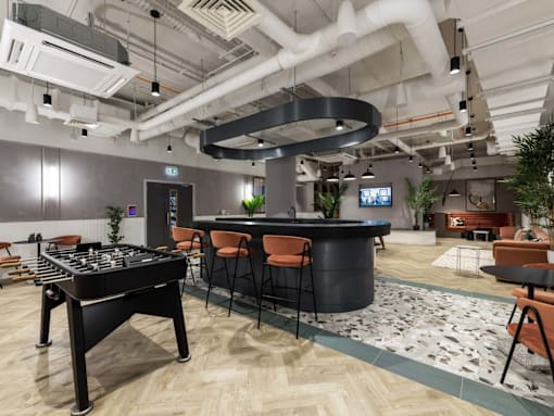 A modern office space with a foosball table in the center.