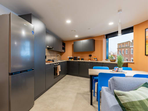 A modern kitchen with a refrigerator, stove, and dining table.