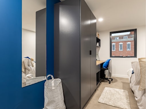 A room with a blue wall and a large mirror.