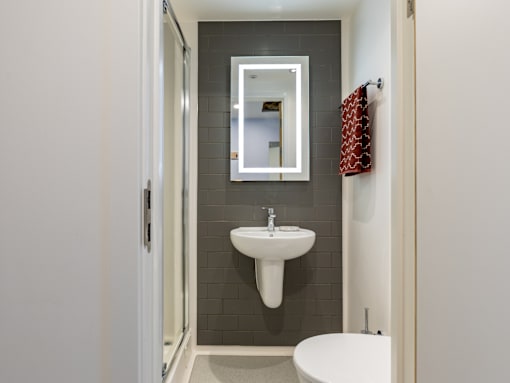 A bathroom with a white sink and a white toilet.