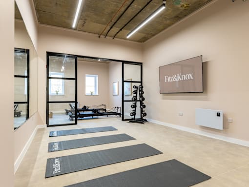 A gym with yoga mats and a sign that says "Fit & Knox".