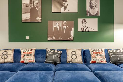 A living room with a blue couch and pictures on the wall.
