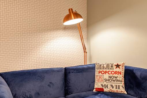 A blue couch with a pillow that says "popcorn" on it.