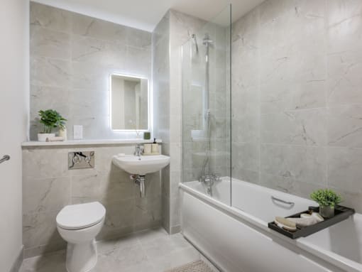 A bathroom with a white toilet, a sink, a bathtub, and a mirror.