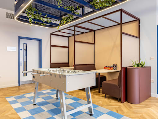 A pool table is in the middle of a room with a blue and white checkered rug.