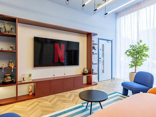 A living room with a flat screen TV mounted on the wall.