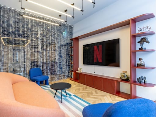 A living room with a large screen and a blue chair.