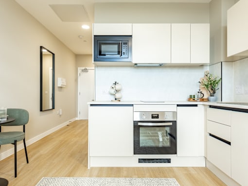 A modern kitchen with white cabinets and a black oven.
