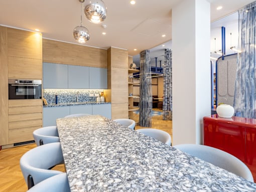 A modern dining room with a long table and chairs.