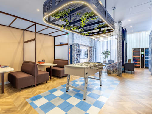 A modern room with a table and chairs and a green plant hanging from the ceiling.