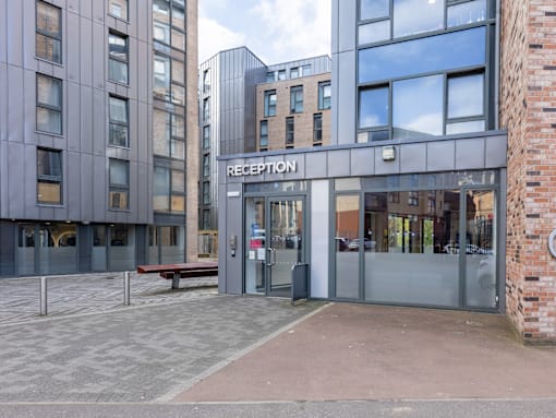 A reception building with a glass door and a bench outside.
