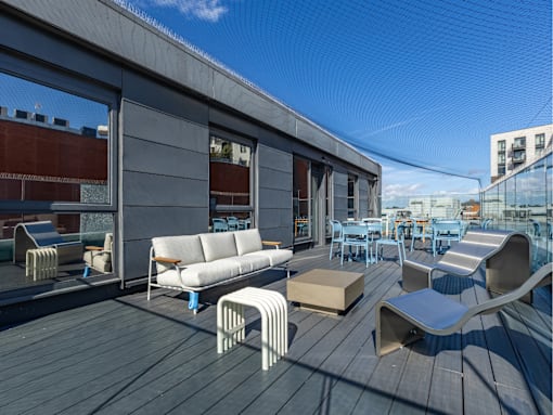 A modern outdoor seating area with a wooden deck and white furniture.