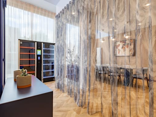 A room with a table and chairs with a curtain in the background.
