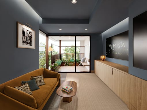 A living room with a yellow couch and a flat screen TV mounted on the wall.