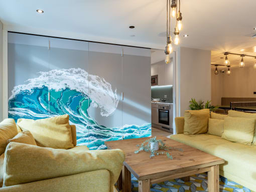 a living room with a large wall mural of a wave