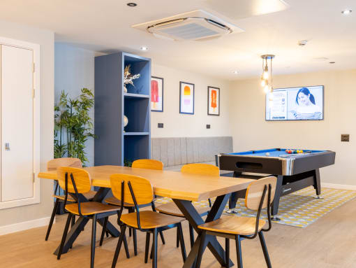a dining room with a table with chairs and a pool table