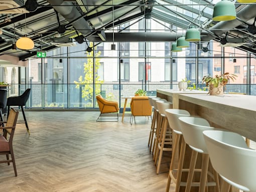 A modern cafe with wooden floors and furniture.