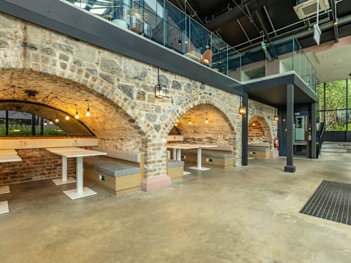 A modern interior with a stone archway and tables.