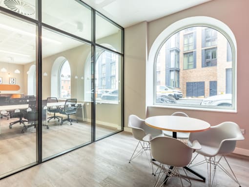 A conference room with a table and chairs and a view of the street outside.