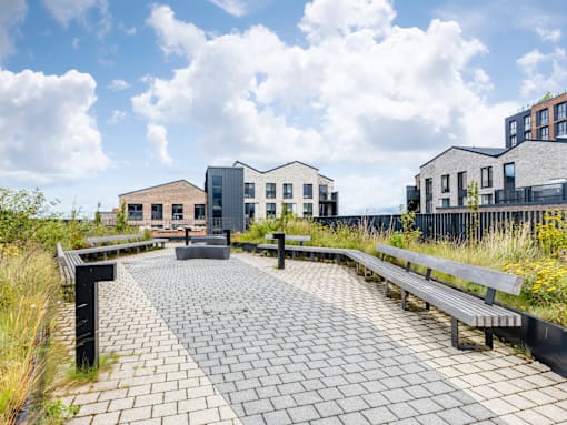 A modern building complex with a paved walkway in front.