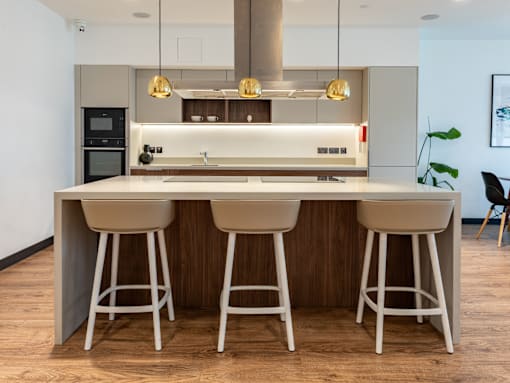 A modern kitchen with a large island and bar stools.