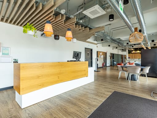A reception area with a wooden counter and chairs.