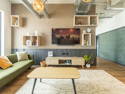 A living room with a green couch, a wooden coffee table, and a painting on the wall.