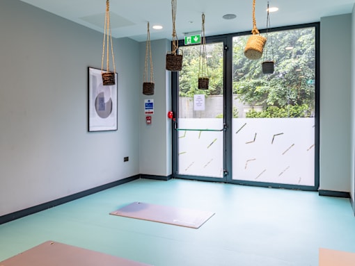 A yoga studio with a pink mat on the floor.