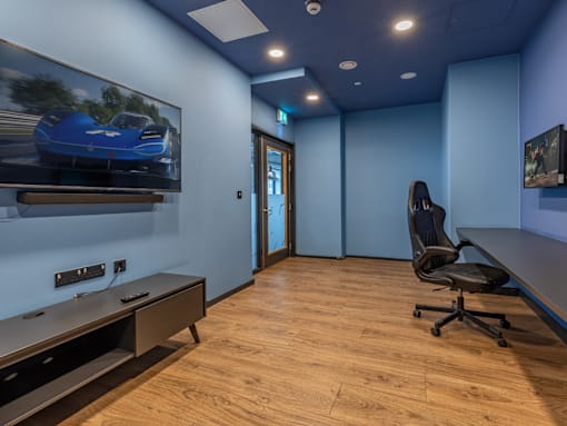 A room with a blue wall and a picture of a blue car on the wall.