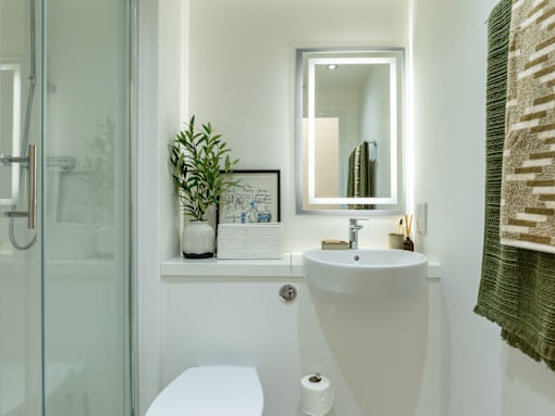 A white toilet sits next to a white sink in a bathroom.