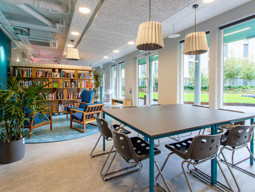 A room with a table, chairs, and a bookshelf.