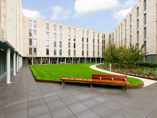 A long bench sits in the middle of a courtyard.
