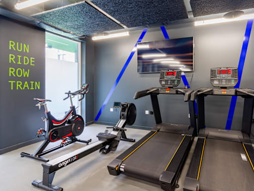 A treadmill and a stationary bike in a gym.