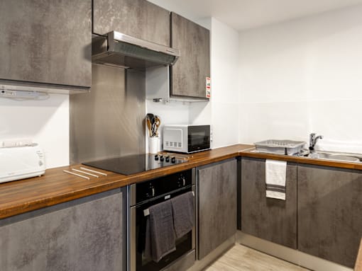 A modern kitchen with a stove top oven and microwave.