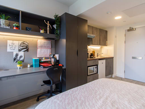 A bedroom with a bed, desk, and chair.
