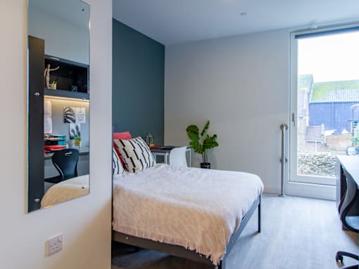 A bedroom with a bed, desk, and chair.