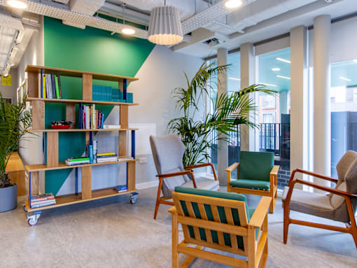 A room with a green wall and a wooden bookshelf.