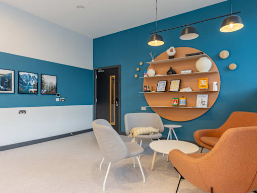 A room with blue walls and a white ceiling has a round shelf with various items on it.