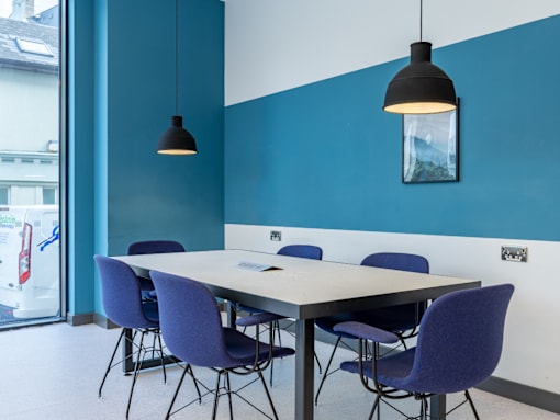 A conference room with a long table and chairs.