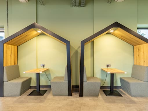 Two booths with wooden tops and grey cushioned seats.