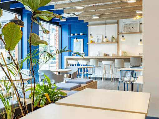A blue and white cafe with a table and chairs.