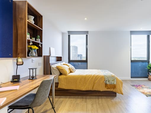 A bedroom with a bed, desk, and chair.