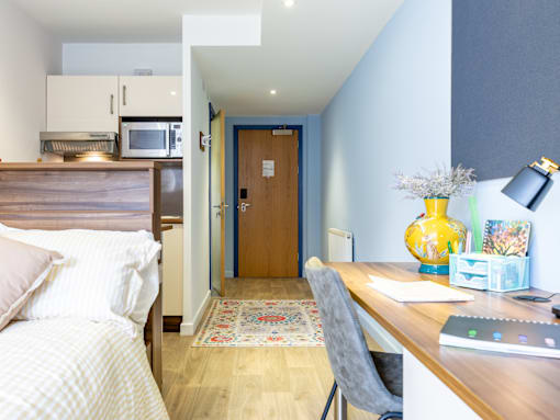 A bedroom with a bed, desk, and chair.