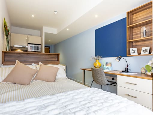 A bedroom with a bed, desk, and chair.