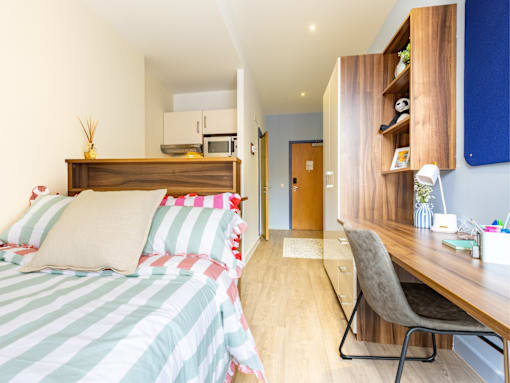 A bedroom with a bed, desk, and chair.